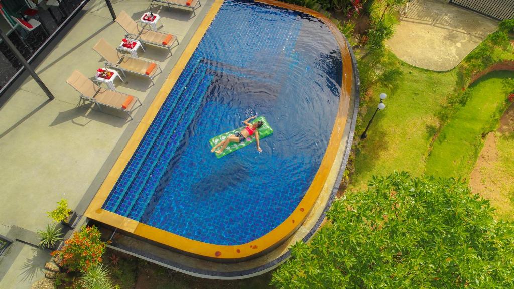 an overhead view of a swimming pool with a person in the water at Chalong -Villa Nap Dau Crown - 8 Br Private Pool Villa - Phuket in Chalong