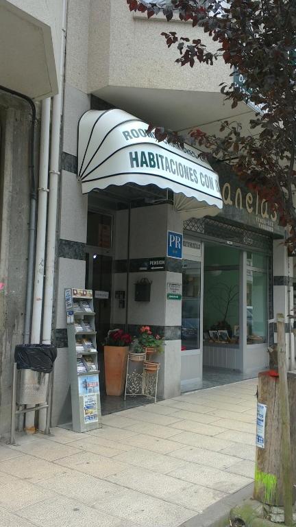 a store with a sign on the front of a building at Hostal Ponte Dos Santos in Ribadeo