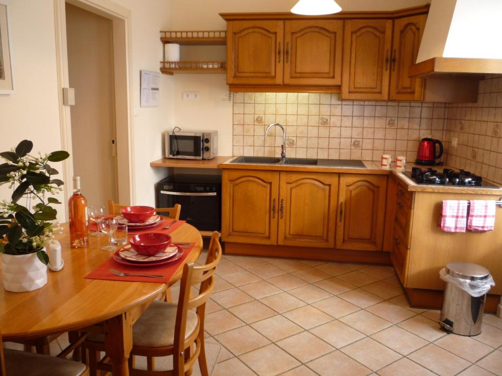 a kitchen with wooden cabinets and a wooden table with a tableablish at Chez Edèll in Monpazier