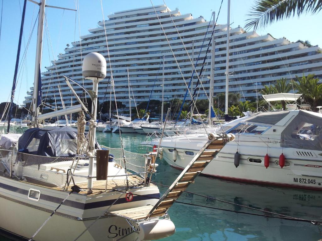 a boat docked in a marina with a large building at Sun Marina Baie in Villeneuve-Loubet