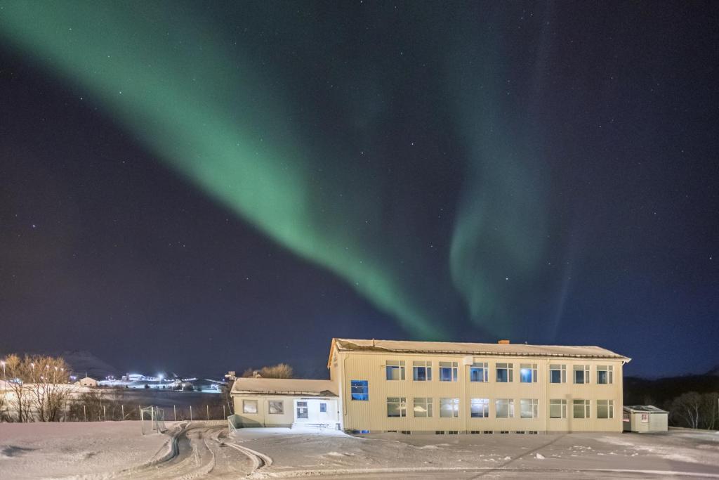 um edifício de escritórios com a aurora no céu em Lofotr Overnatting em Bøstad