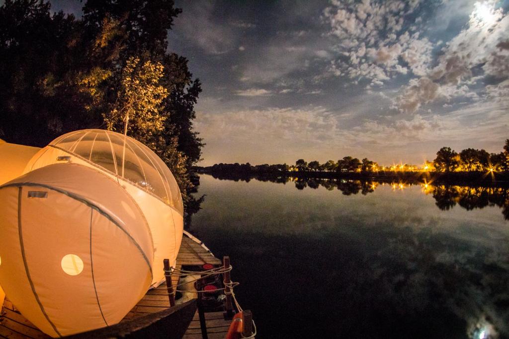un bateau assis sur un quai sur un lac dans l'établissement Péniche Espoir bulle, à Avignon