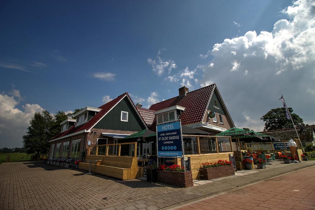 una casa grande con un cartel delante en Hotel B&B d'Olde Smidse en Giethoorn