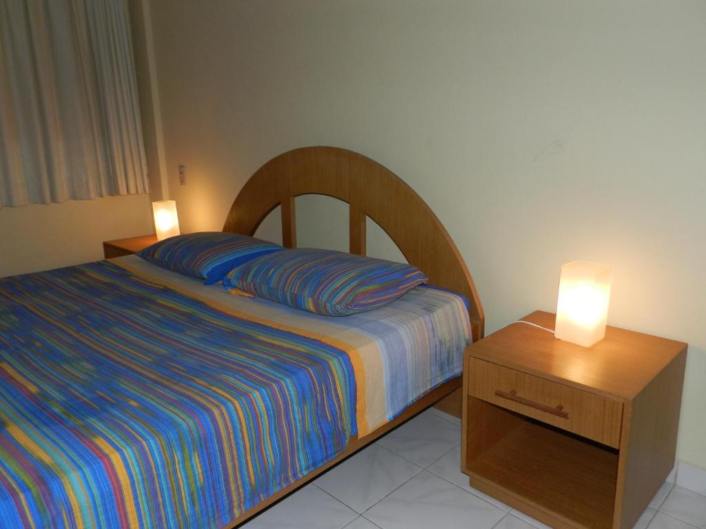 Aparthotel Eporedia في ناتال: غرفة نوم مع سرير وطاولة مع مصباحين