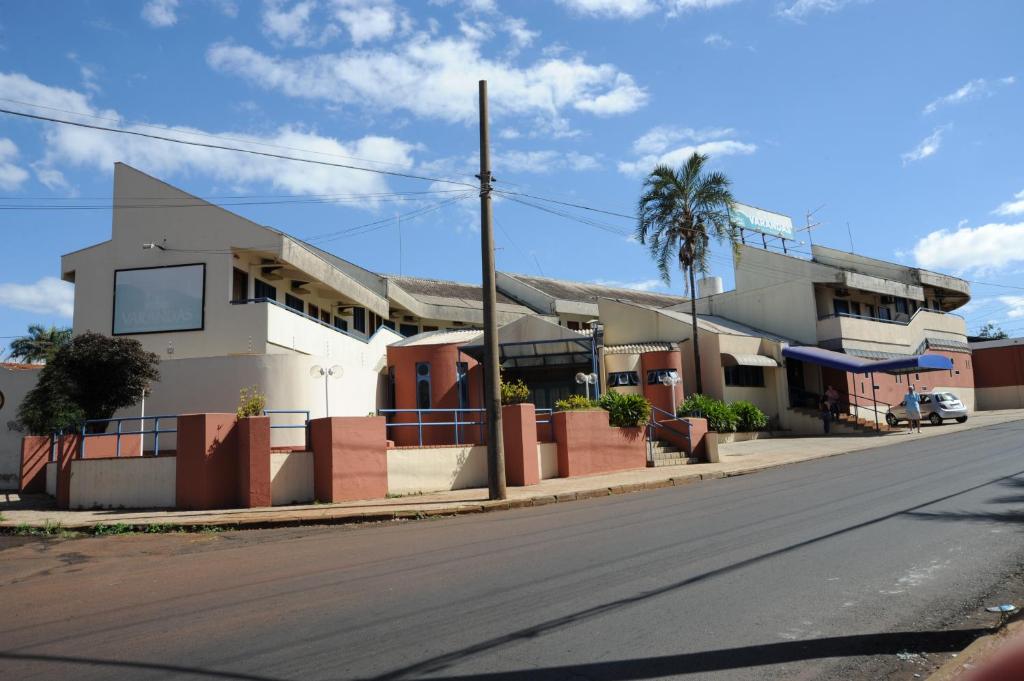 a building on a street with a palm tree at Hotel Varandas Araraquara in Araraquara