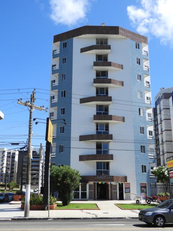 un edificio blanco alto en la esquina de una calle en Apartamento Beira Mar Maceio Cote D'Azur, en Maceió