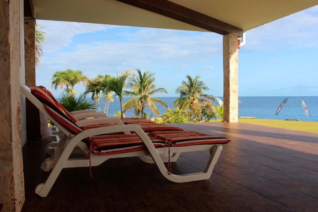 a chair on a porch with a view of the ocean at Relax On The Caribbean in Río San Juan