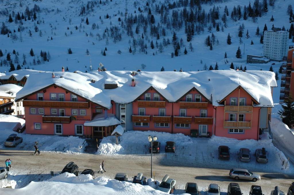 a building covered in snow with snow covered roofs at Hotel Panorama in Passo del Tonale