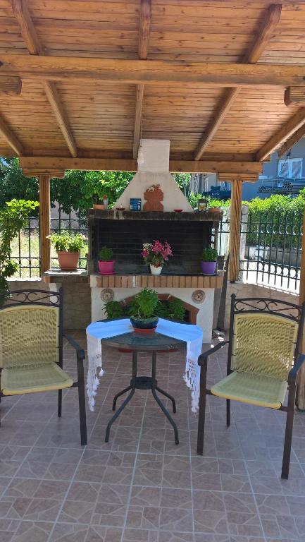 a patio with a table and chairs and a fireplace at Dimitra Pentaliou Rooms in Kamena Vourla