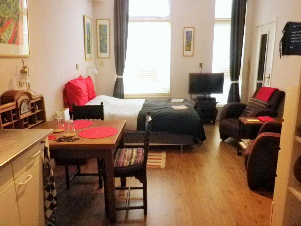 ein kleines Wohnzimmer mit einem Bett und einem Tisch in der Unterkunft Appartement centrum Groningen in Groningen
