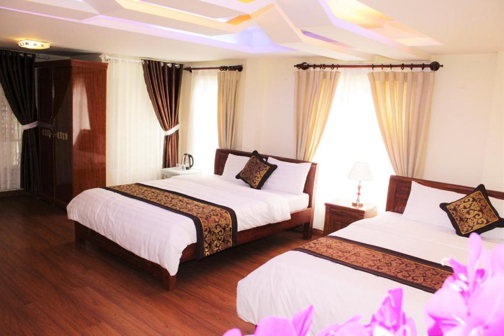 2 camas en una habitación de hotel con techo en Thien Phu Guesthouse Dalat, en Da Lat