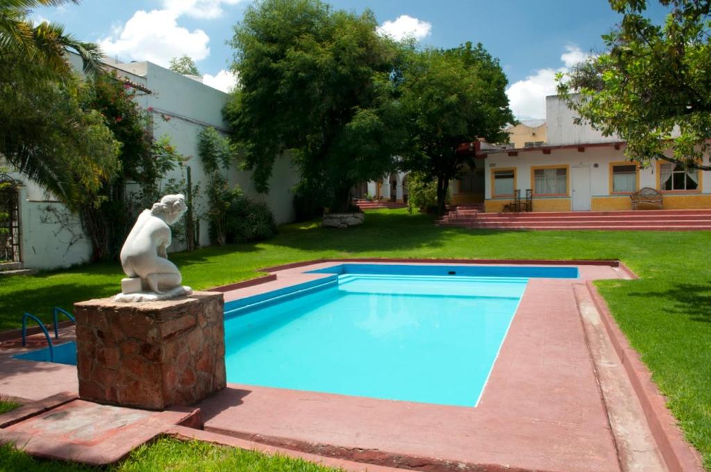 a statue sitting next to a swimming pool at Posada San Francisco in Tequisquiapan