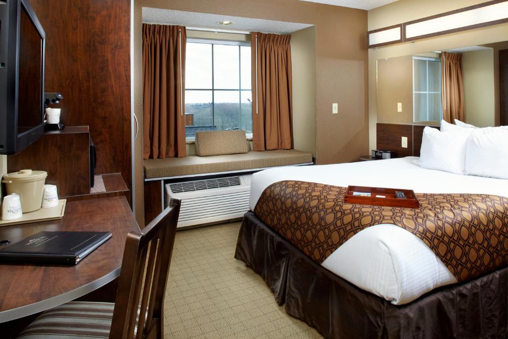 a hotel room with a large bed and a desk at Microtel Inn & Suites by Wyndham Wheeling at The Highlands in Triadelphia