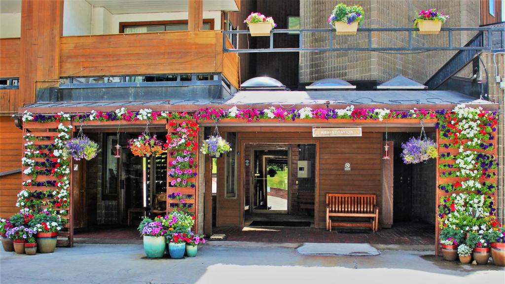 Vail Run Resort في فيل: مدخل لمبنى به زهور ونباتات