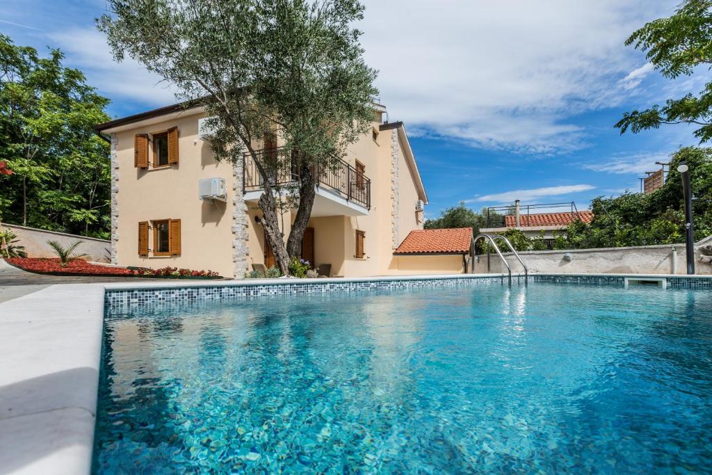 een zwembad voor een huis bij Apartments Villa Diamant with Pool & Whirlpool in Čižići