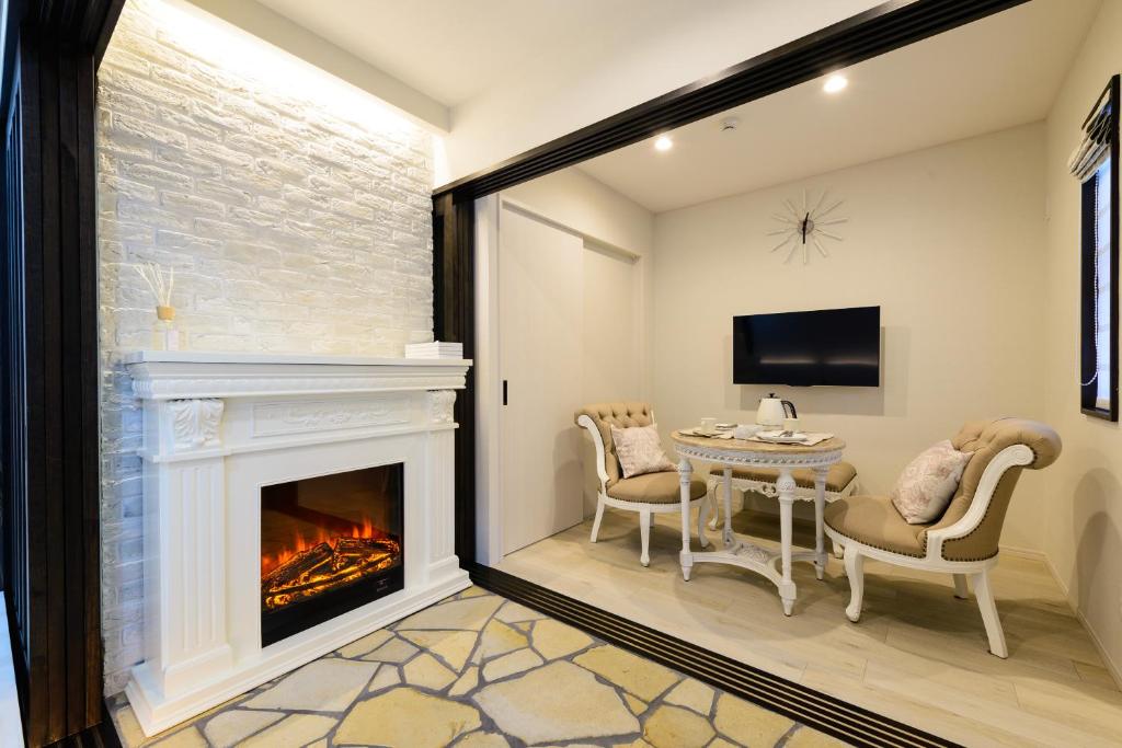 a living room with a fireplace and a table and chairs at Guest Villa Hakone Yumoto 101 in Hakone