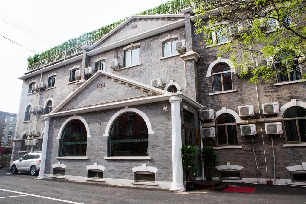 een bakstenen gebouw met een auto ervoor geparkeerd bij Nostalgia Hotel Beijing South Luogu Lane, Ghost Street, Beixinqiao Metro Station in Beijing