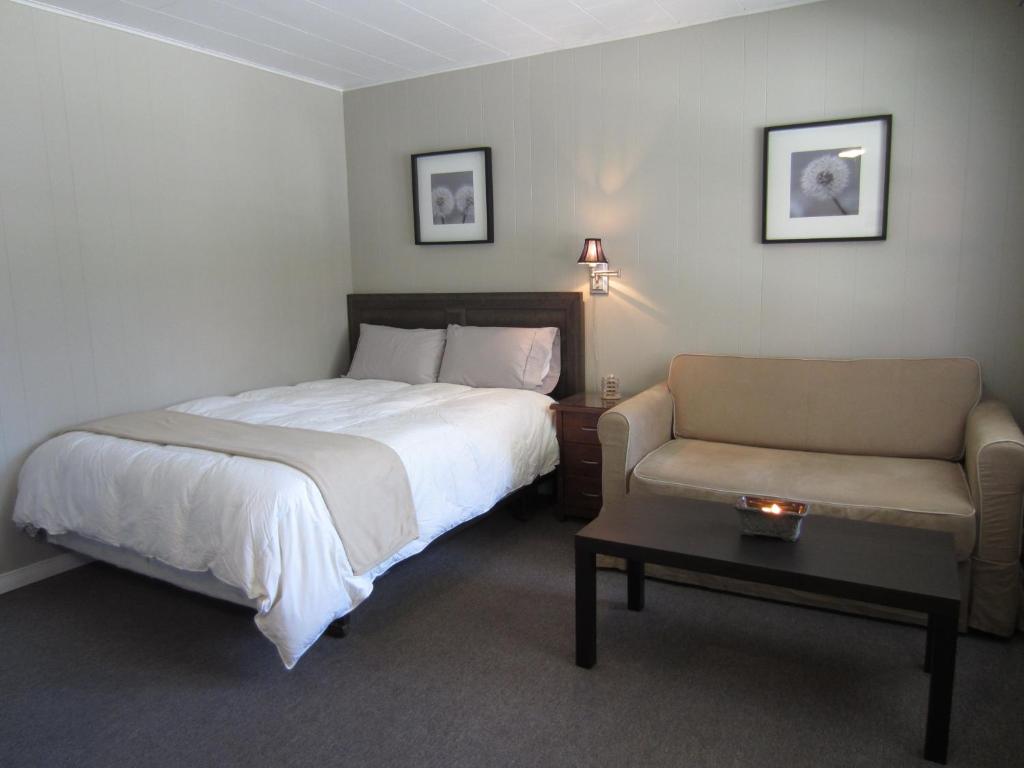 1 dormitorio con cama, sofá y mesa en Balm Beach Resort and Motel, en Balm Beach