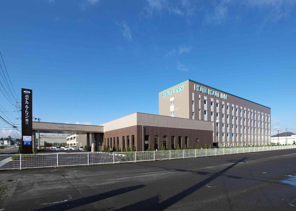 a large building with a parking lot in front of it at Hotel Route-Inn Sabae -Kokudou 8 Gou- in Sabae