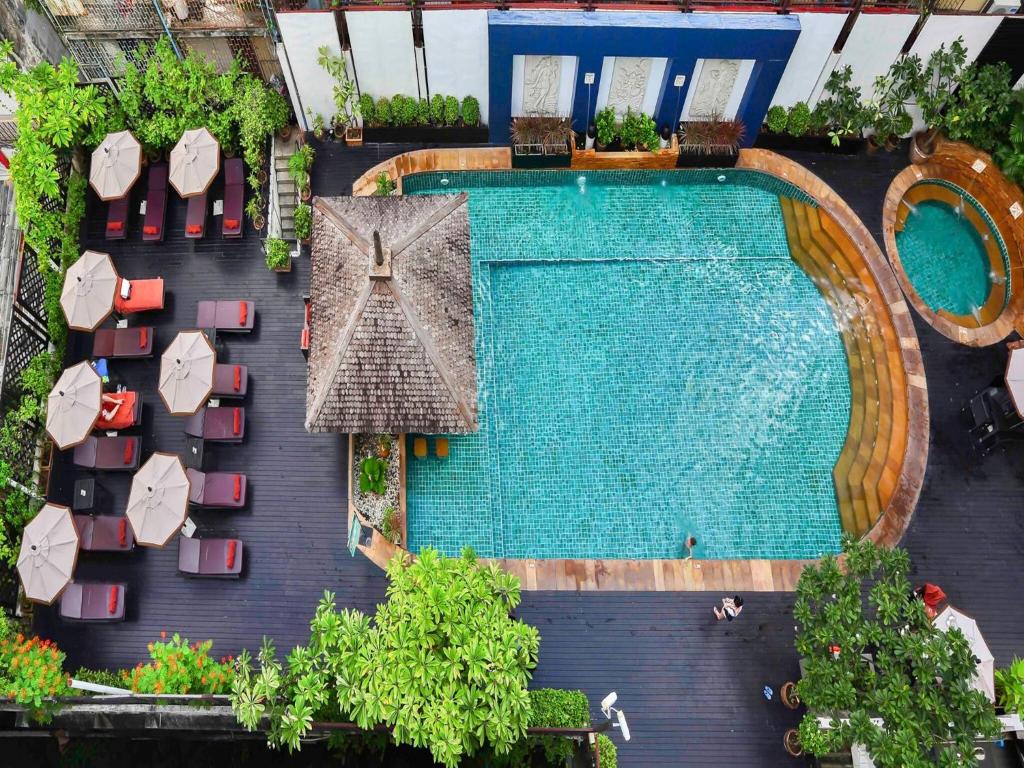 an overhead view of a swimming pool with chairs and umbrellas at Sunbeam Hotel Pattaya - SHA Extra Plus in Pattaya Central