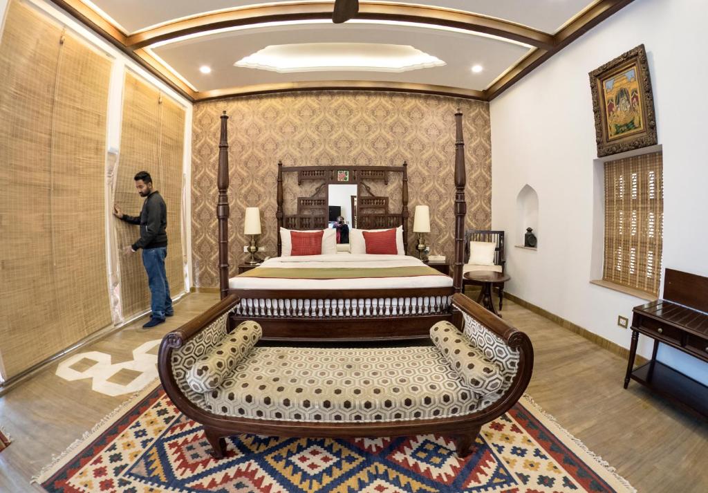 a man standing in a hotel room with a bed at Haveli Dharampura - UNESCO awarded Boutique Heritage Hotel in New Delhi