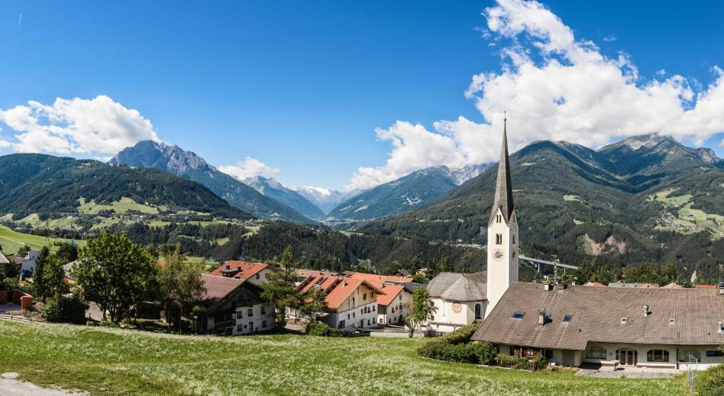 a village with a church and mountains in the background at Bärenwirth in Innsbruck