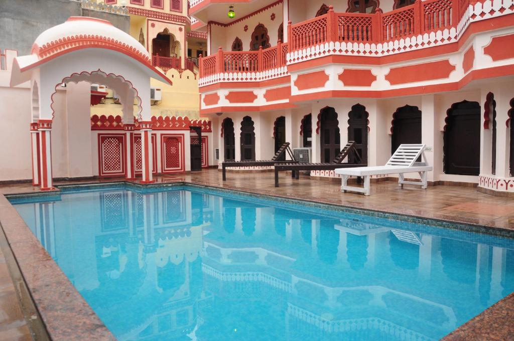 a swimming pool in a courtyard of a building at Sajjan Niwas in Jaipur