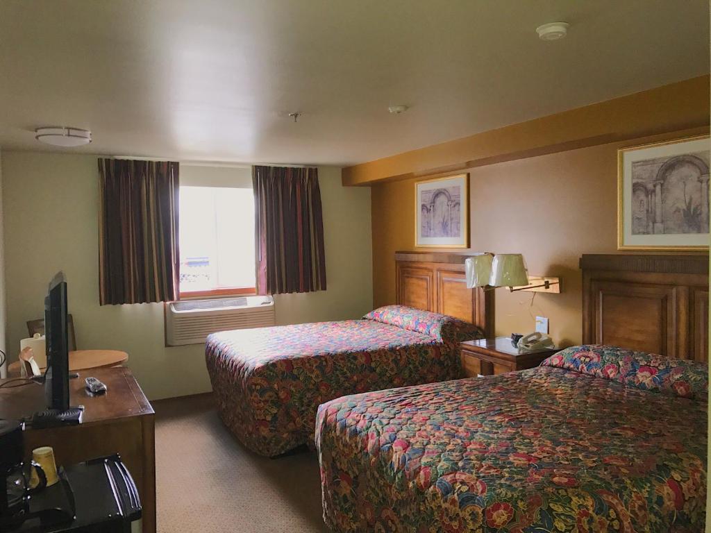 a hotel room with two beds and a television at Bay City Motor Inn in Bellingham