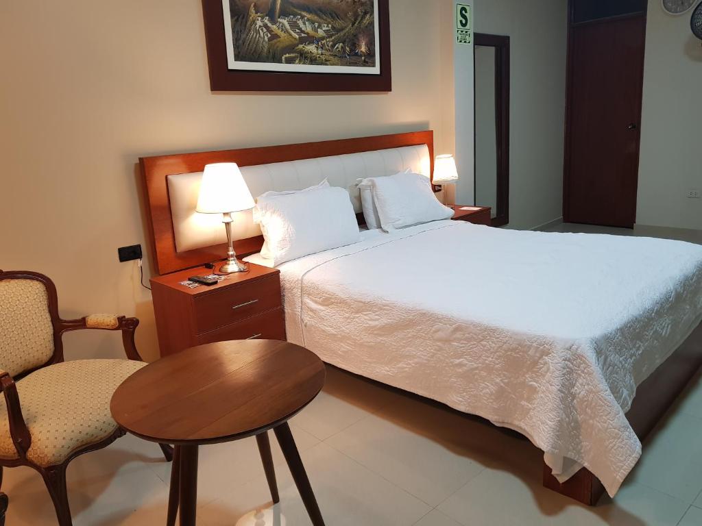a bedroom with a bed and a table and a chair at Hotel San Antonio in Bagua