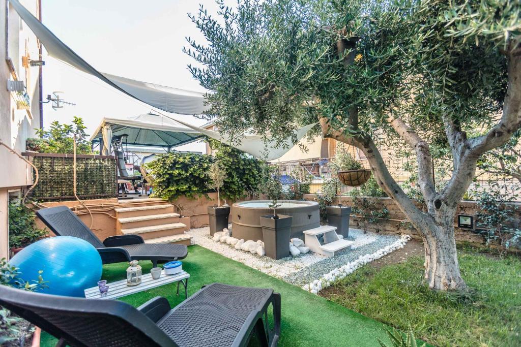 a backyard with a barbecue grill and a tree at Tarchon Luxury B&B in Tarquinia