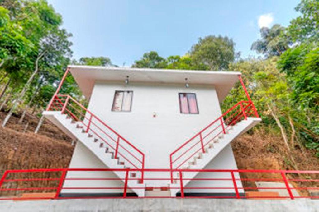 a white house with red rails on the side of it at Sunleo Spice Villas & Homestay in Munnar