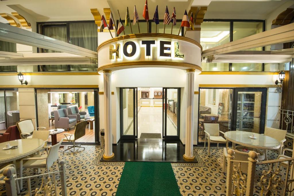 伯薩的住宿－Ruba Palace Thermal Hotel，酒店大堂设有桌椅和酒店标志