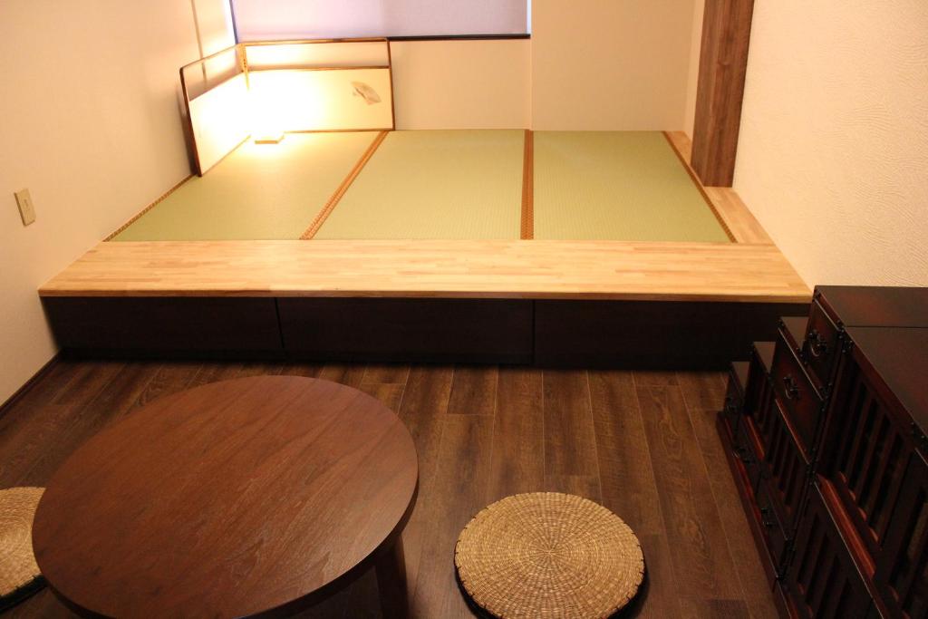 Habitación pequeña con cama, mesa y silla en Vacational Rental Sunny Heights en Kanazawa