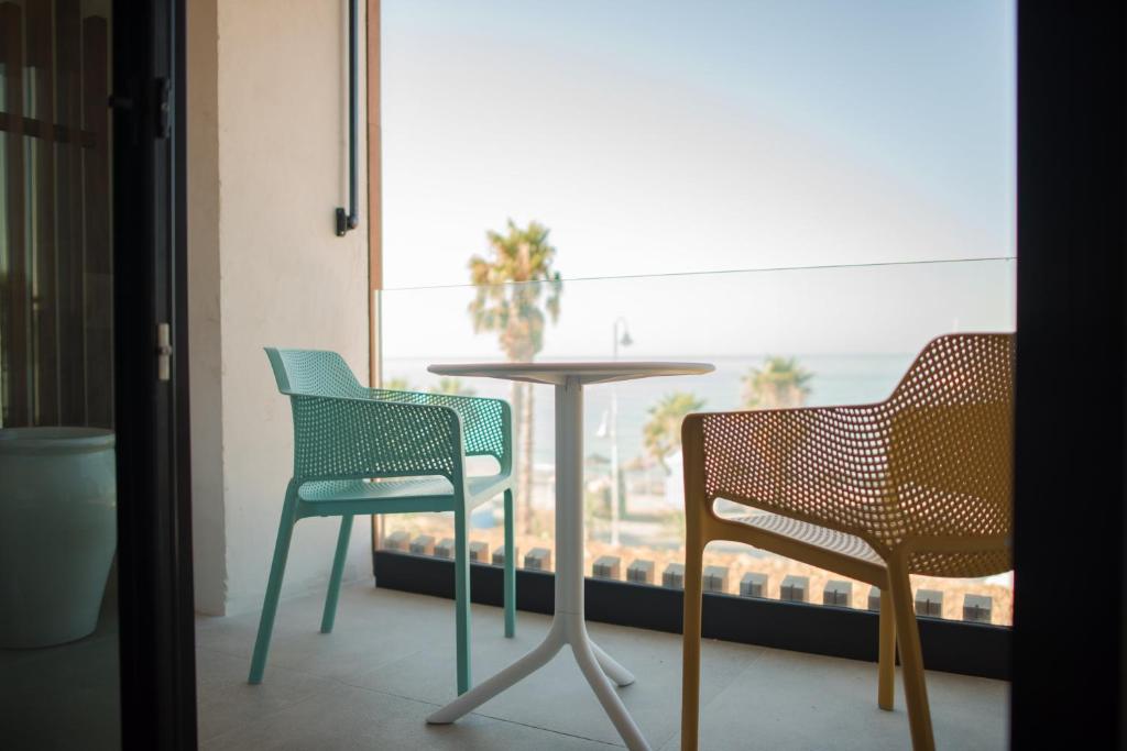 two chairs and a table in front of a window at H Boutique Peña Parda in La Herradura