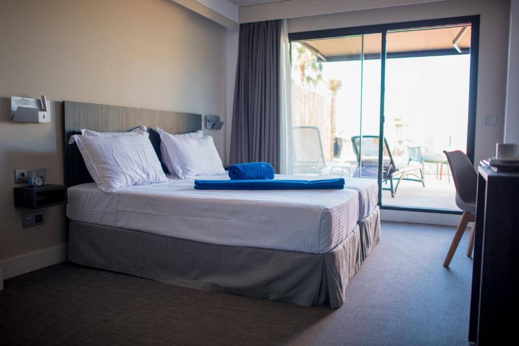 a hotel room with a bed with a view of a patio at H Boutique Peña Parda in La Herradura