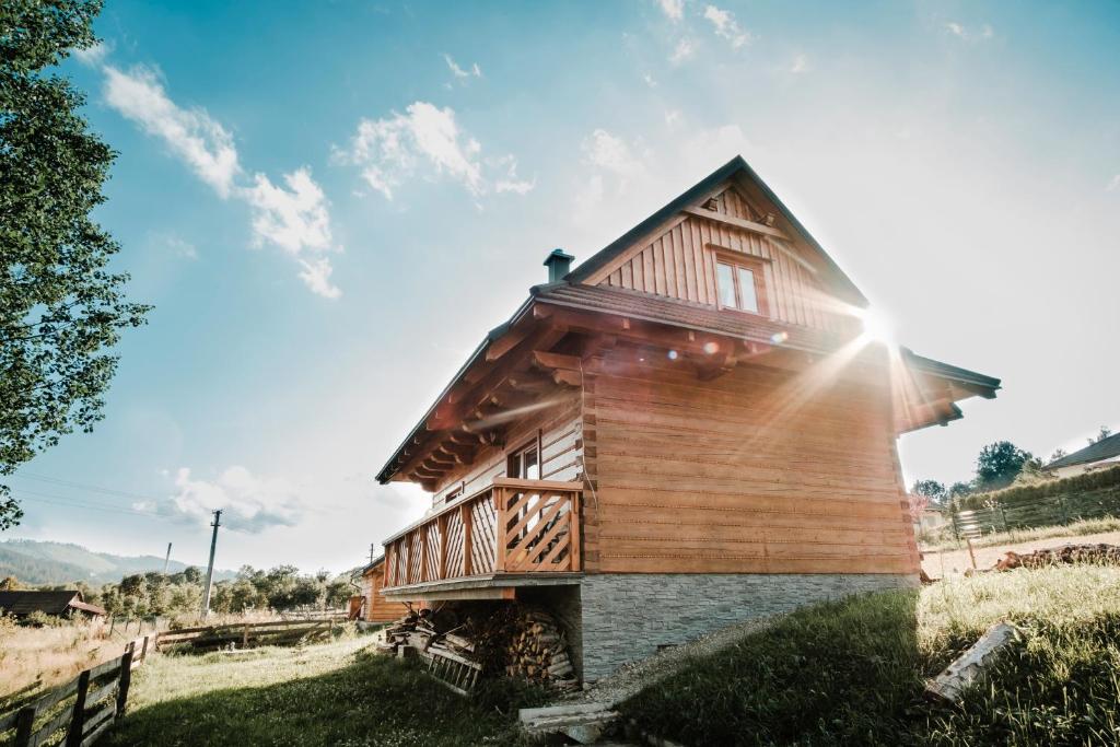 een klein houten huis met de zon op de achtergrond bij Chata nad Briežkami in Raková