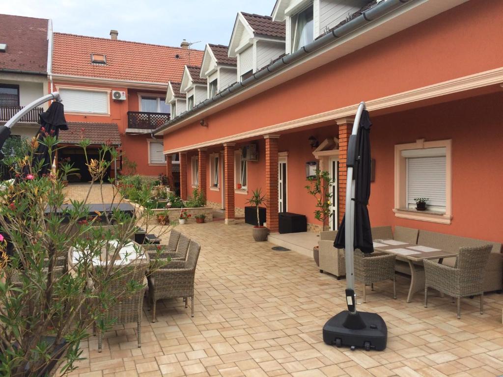 een binnenplaats met een tafel en stoelen en een parasol bij Csillag Panzió in Vác