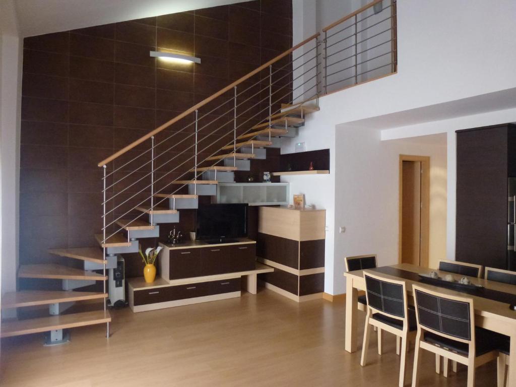 una scala in un soggiorno con tavolo e sedie di Apartamento Quixote Loft Almagro ad Almagro