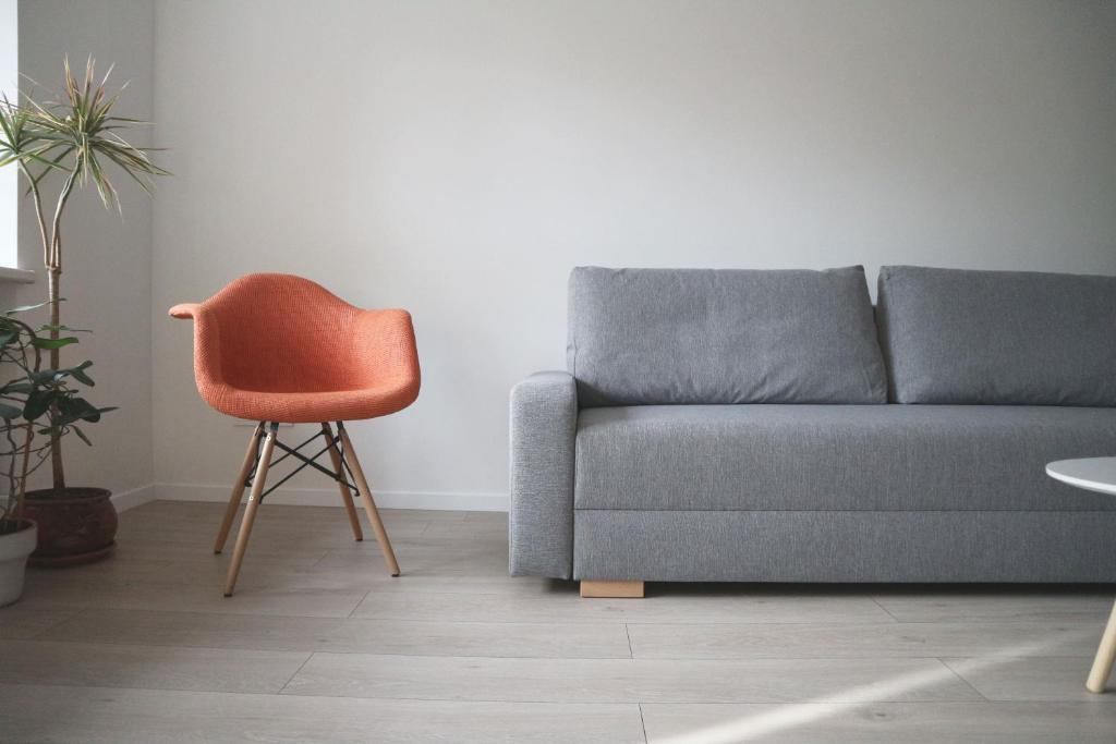 a living room with a couch and a chair at Blue city apartment in Klaipėda