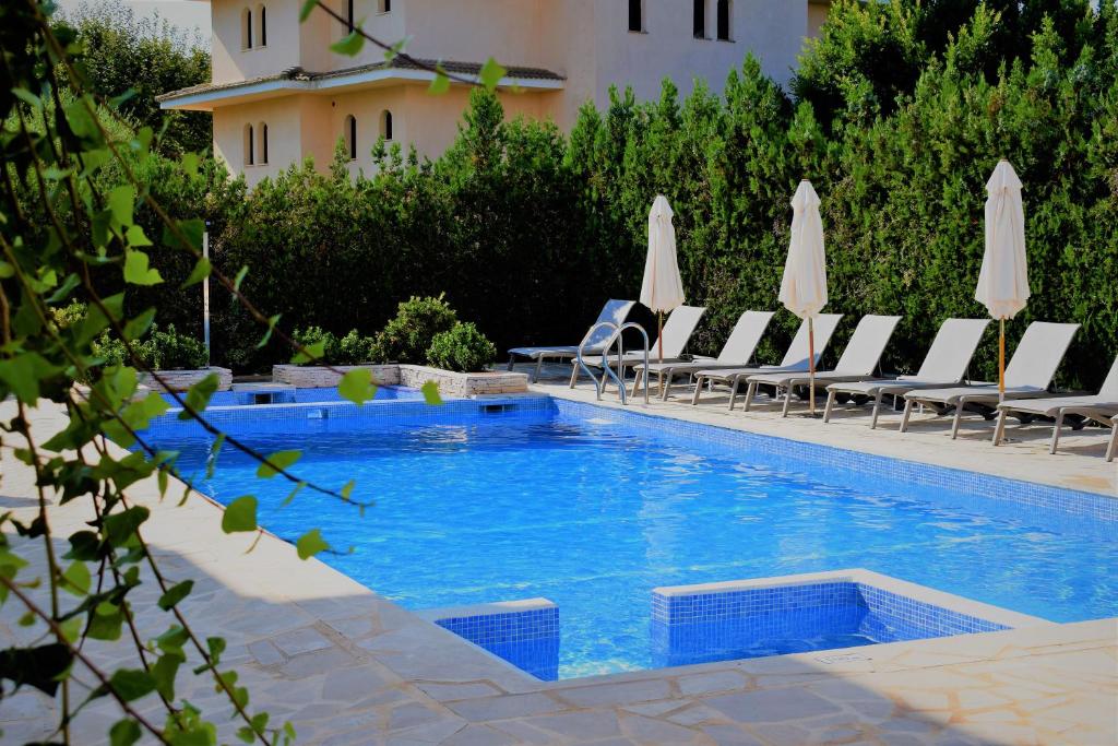 a swimming pool with lounge chairs and umbrellas at Apartamentos Sureda in Canyamel