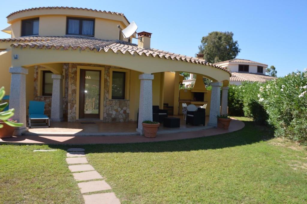 a small yellow house with a patio at Nuova Valmar Villa Condominio Rei Sole in Costa Rei