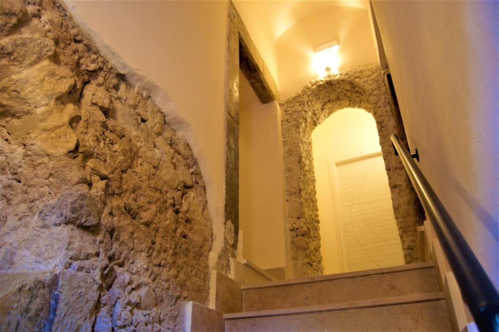 a stairway with a mirror and a stone wall at B&B The Tower in Tropea