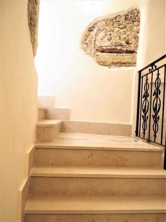 a set of stairs in a room with a stone wall at B&B The Tower in Tropea