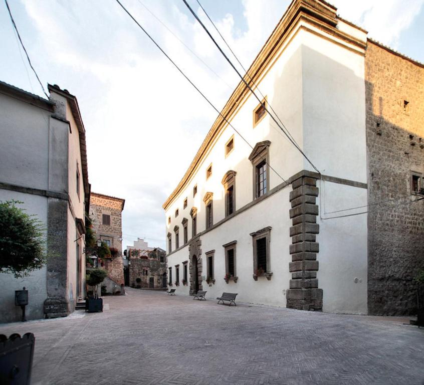 une allée vide avec un bâtiment blanc et une rue dans l'établissement Palazzo Orsini, à Mugnano