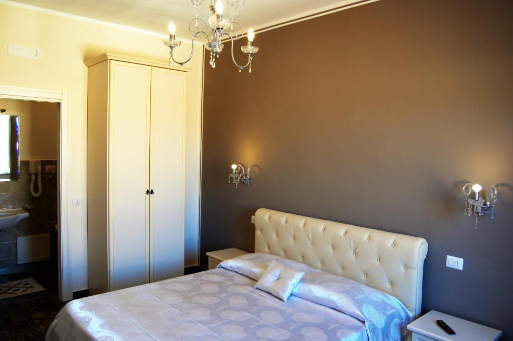 a bedroom with a bed and a chandelier at B&B The Tower in Tropea