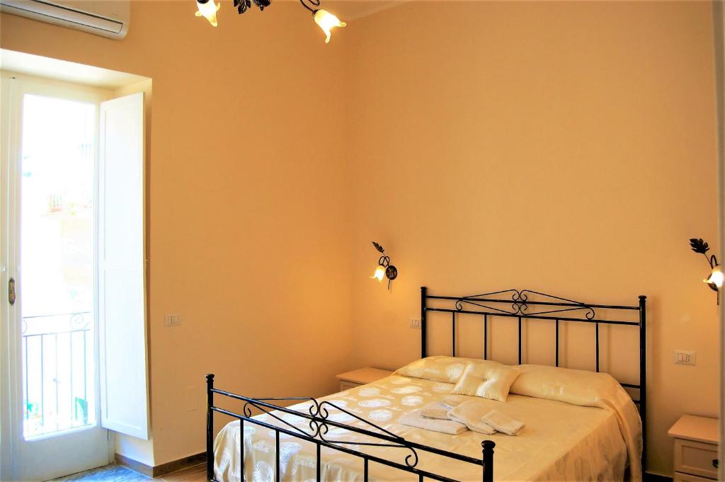 a bedroom with a bed and a large window at B&B The Tower in Tropea