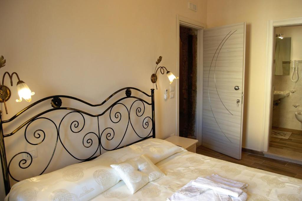 a bedroom with a black and white bed and a bathroom at B&B The Tower in Tropea