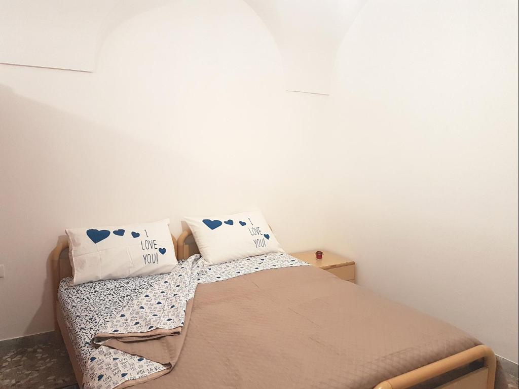 una piccola camera da letto con un letto con due cuscini di Casa Eleonora a Monopoli