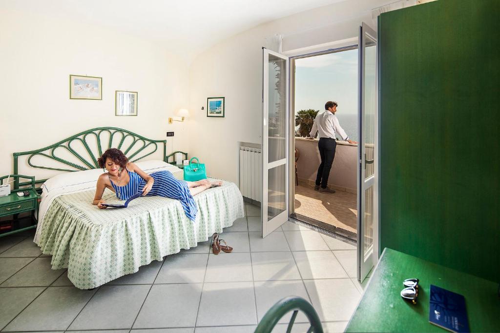 a woman laying on a bed in a bedroom at Sorriso Thermae Resort & Spa in Ischia