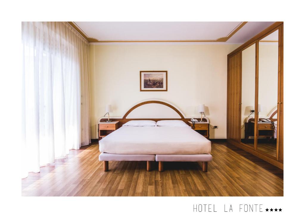 Un pat sau paturi într-o cameră la La Fonte Hotel